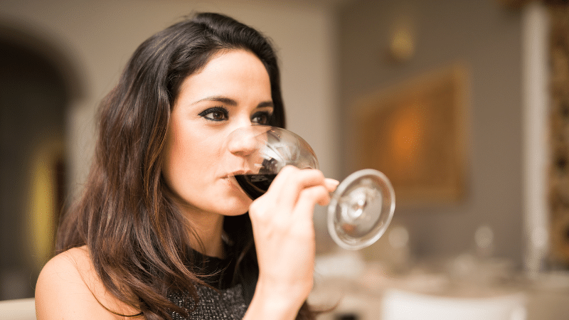 mulher bebendo vinho treinar melhora a disposição