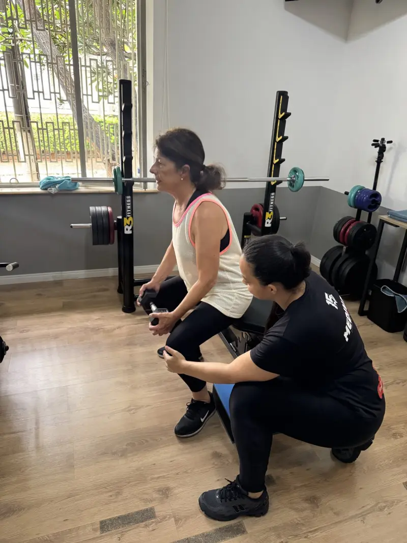 Professora do Studio Medina Plus acompanhando a aluna de perto durante o treino